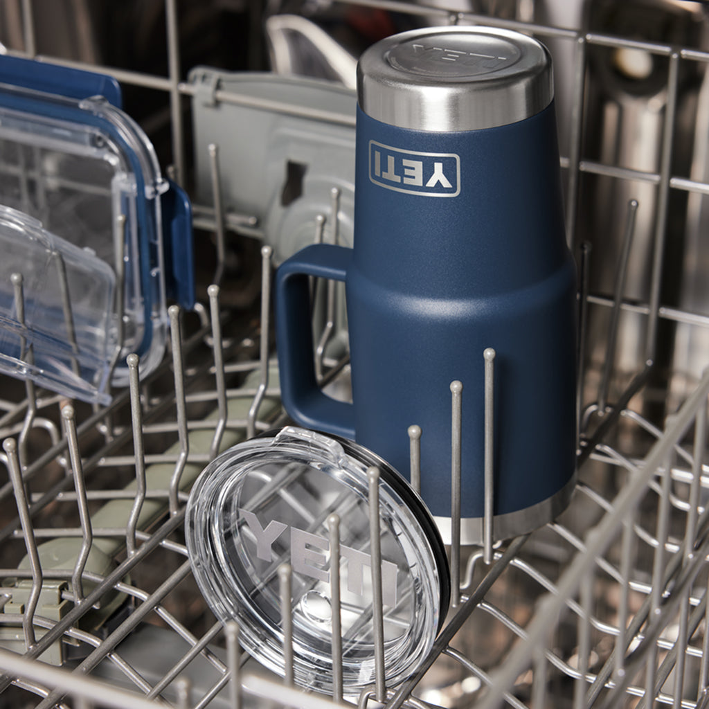 Blue YETI insulated mug with clear straw lid inside a dishwasher.