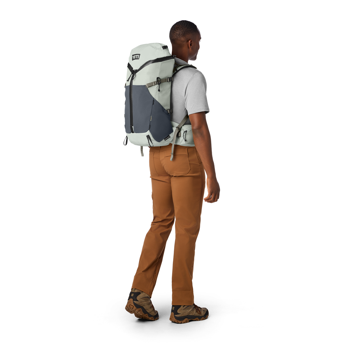 Person wearing a large backpack on a white background
