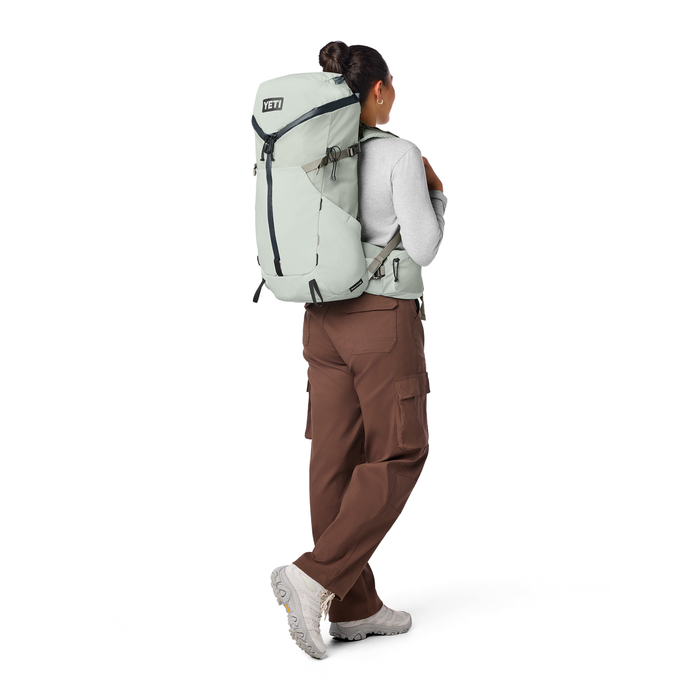 Person wearing a large backpack with a white background