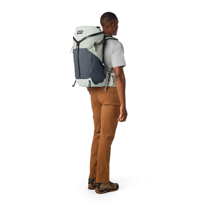 Person wearing a large backpack on a white background